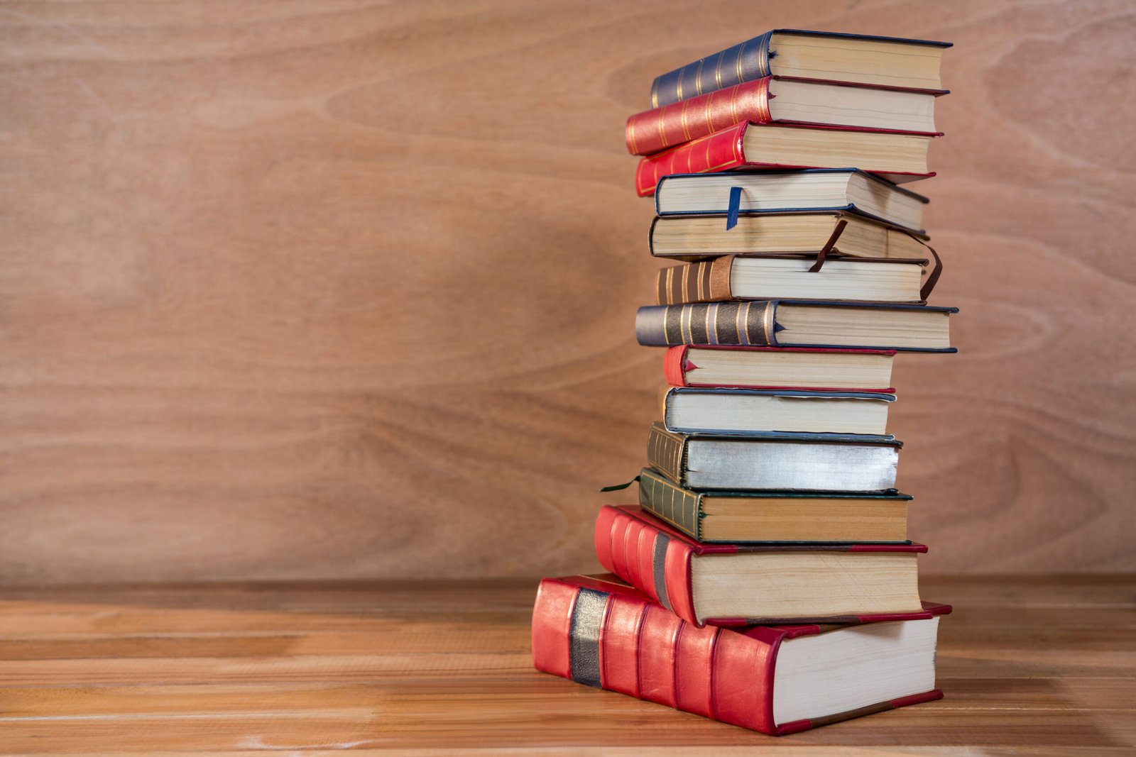 Stack of various books on a wooden table